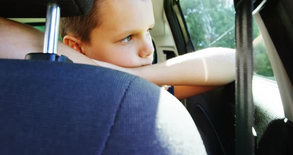 Boy relaxing in the back seat of car