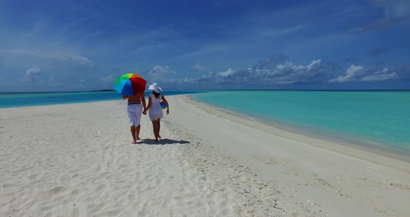 Romantic couple on honeymoon vacation have fun on beach on summer white sandy 4K background