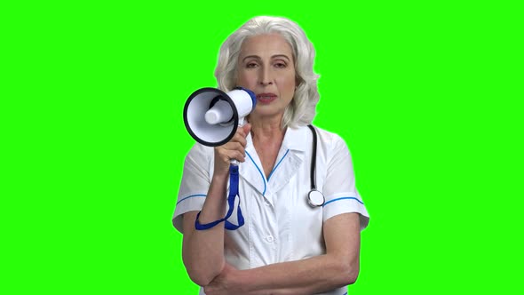 Elderly Female Doctor Talking Into Megaphone.