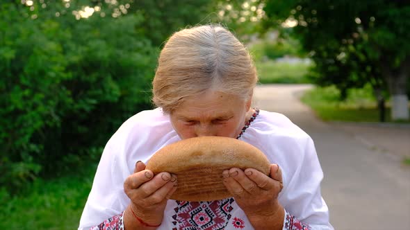 Grandmother with Ukrainian Bread in Her Hands