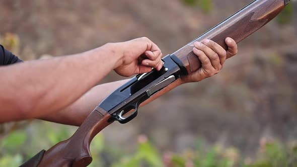 Close Up of a Hunter Hands Unloading a Shotgun. Slow Motion.