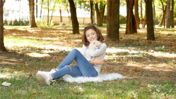 A Child with a Puppy in Autumn