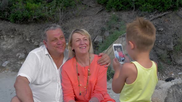 Child Taking Picture of Grandparents with Cell Phone