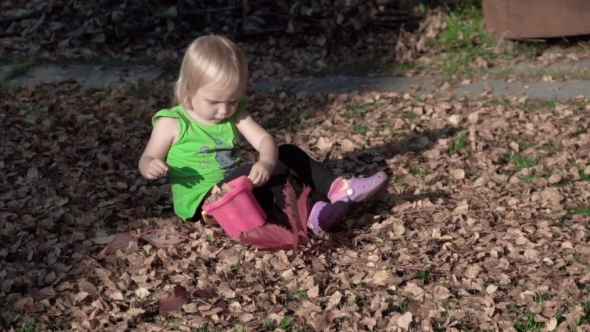 Cute Baby Girl Playing With Leaves In Autumn
