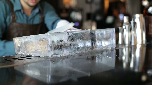 Bartender Sawing Ice On The Bar With a Saw