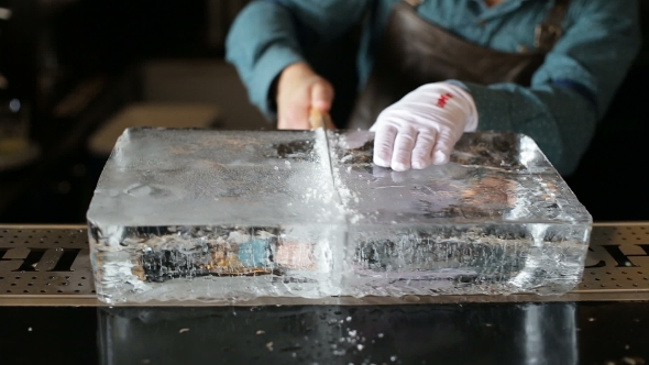 Bartender Sawing Ice On The Bar With a Saw