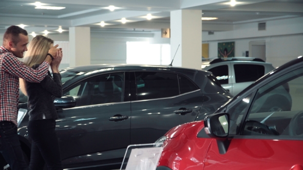 Man Surprising Woman With New Car In Show Room