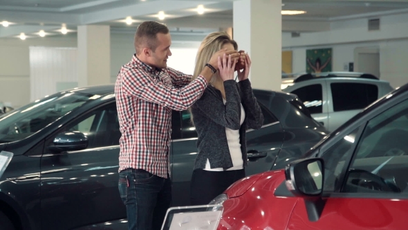 Man Surprises Wife Or Girlfriend In Car Dealership, Showing New Car