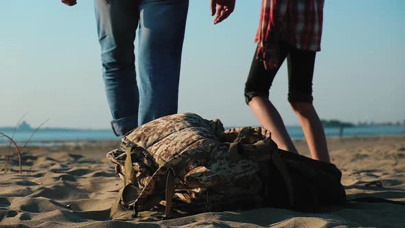 happy family throw their backpacks on sand and walk along sand to sea.