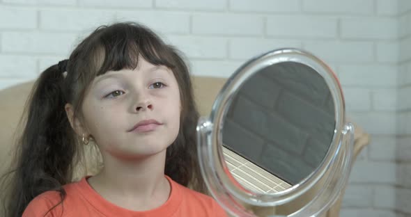 Child Looking Face in Mirror