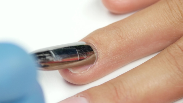 Manicurist Works On The Nail With a Spatula And Pushes Back Cuticles.