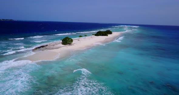 Wide angle overhead clean view of a white paradise beach and blue sea background in colourful 