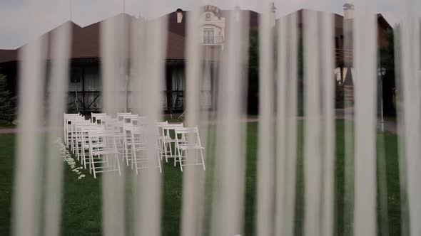 beautiful wedding arch in the park with white chairs