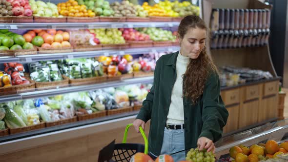 Female Customer Take a Grape From the Food Counter