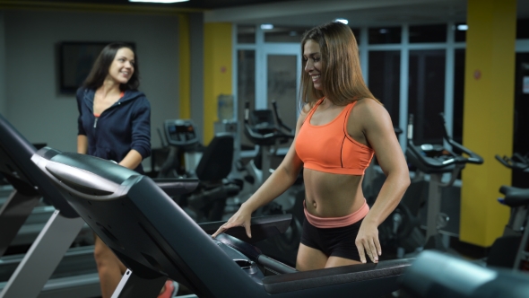 Two Fitness Girls On Running Machines