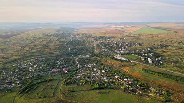 Aerial drone view of village in Moldova. Residential buildings, greenery, fields around