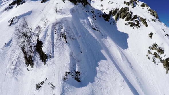 Quadrocopter Shoot Snowboarder Free Ride From Peak Of Snowy Mountain. Failing