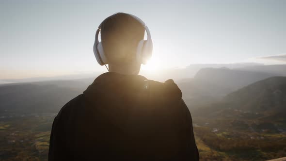 silhouette of man listens to music at sunset