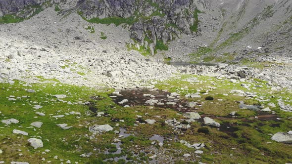 AERIAL: Slowly Flying Over Puddle of Water on the Mountain