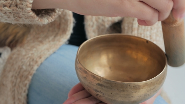 Young Woman In Cardigan Relaxing With Nepal Singing Bowl