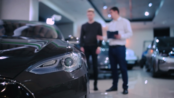 Manager Talking With Man Near Electric Car