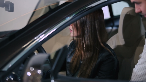 Woman Testing The Electric Car Inside Of Car