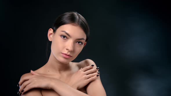 Portrait Pleasant Mixed Race Young Feminine Stroking Shoulders Face Skin Enjoying Moisturizing Cream