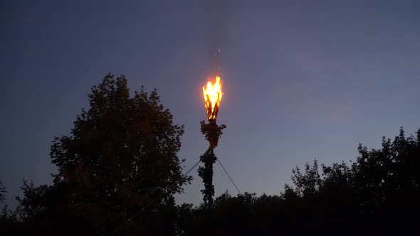 Midsummer A Latvian man with an oak leaf wreath lighting up a pūdele (a container filled with tar, d