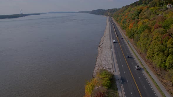 Aerial of Great River Road in Autumn as a white van approaches. Camera descends.