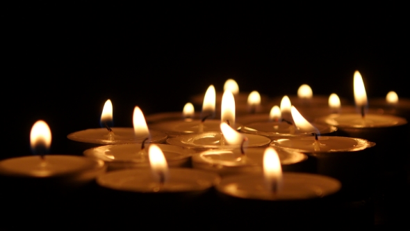 Tea Candles Burning In The Darkness