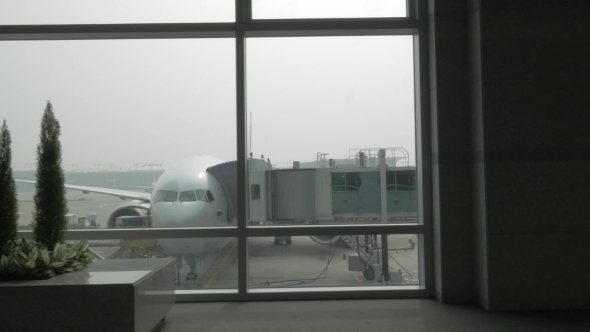 Unloading The Plane With Attached Air Bridge, View From The Window