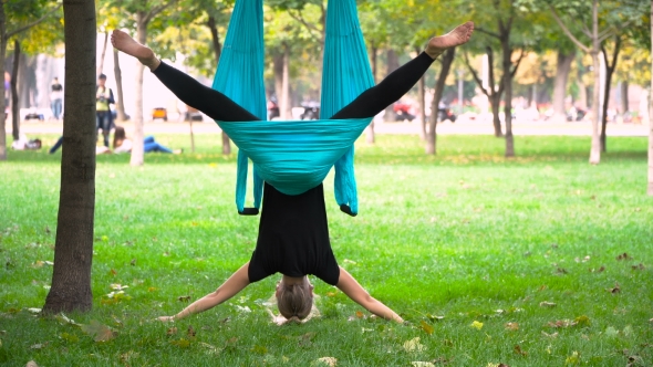 Girl In a Park Engaged In Aerial Yoga