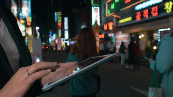 Woman Browsing In Web On Pad In Night Seoul, South Korea