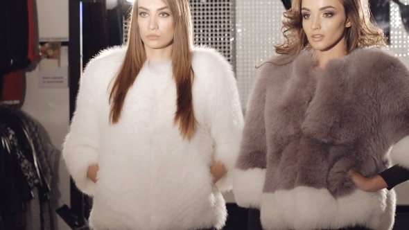 Two Models Posing In Fur Coats In Fashionable Rich Boutique. Slowly