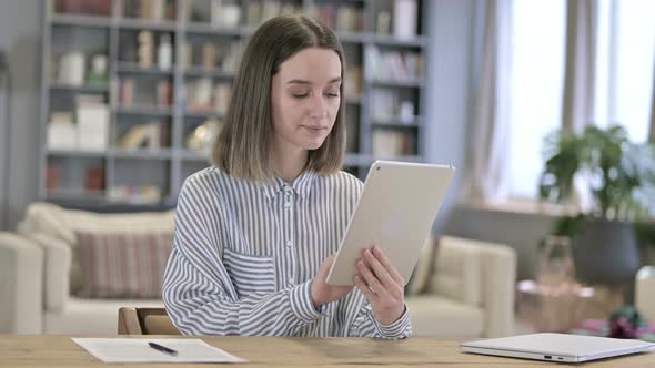 Focused Young Woman Using Tablet in Office