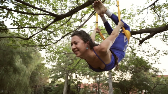 Aerial Yoga Practitioner Stretches Herself While Suspended On Hammock.