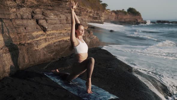 Girl Doing Stretching on Mat at Stone Black Beach Near Ocean