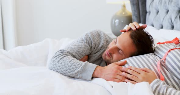 Couple feeling the presence of baby in stomach at home 