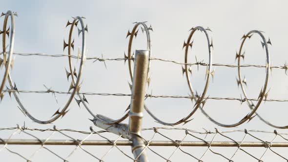 Endless view at the top of prison or airport fence on blue sky background. 4k HD