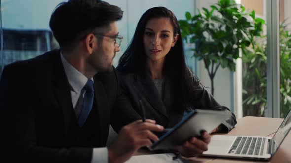 Two colleagues discuss data analyzing marketing using laptop or notebook  having business