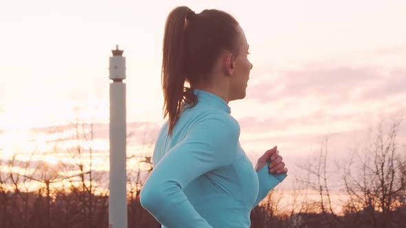 Young, beautiful and sporty woman having evening training outdoor.