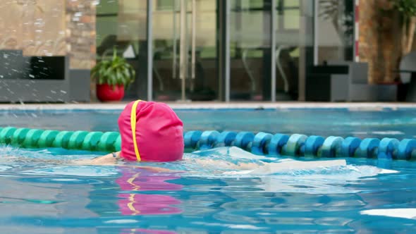 Cheerful Girl in Goggles Bathing in the Pool