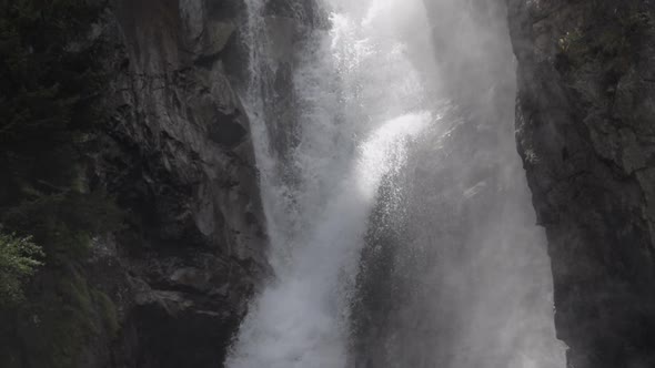 Detail static slowmotion shot of the La Pisse waterfall. The water goes down and up. French Alps. Pr