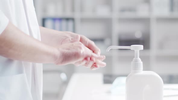 Close-up of doctor cleaning hands using disinfectant with medical soap.