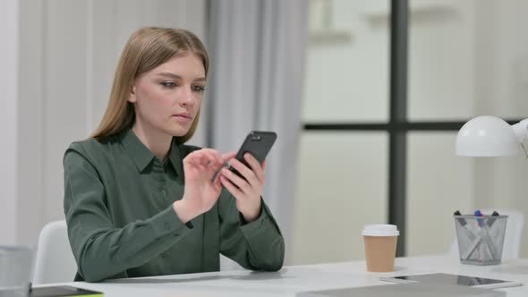 Attractive Young Woman Using Smartphone at Work 