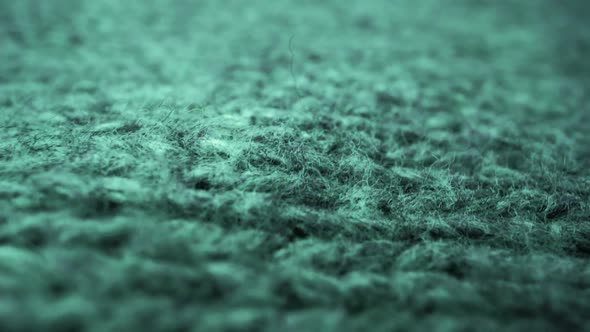 Extreme detail view of sheep wool cloth texture flowing in macro dolly shot.