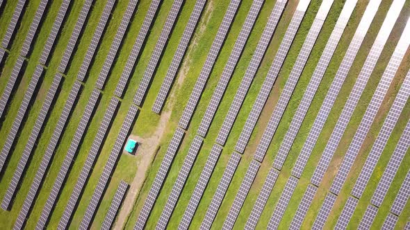 Aerial view of solar power plant on green field. Electric panels for producing clean ecologic