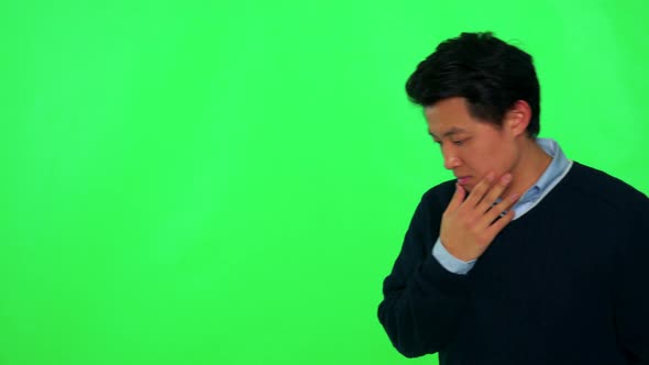A Young Asian Man Rubs His Chin, Looks Concerned and Walks Back and Forth - Green Screen Studio