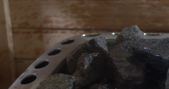 Pouring water on the rocks from a sauna heater. Water evaporated by hot stones
