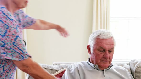 Senior woman kissing senior man in living room